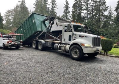 Truck with dumpster being delivered to a house in Woodway, Wa