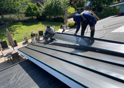 Two men installing a metal roof in Edmonds, Wa.