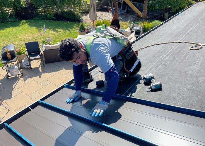 Man installing a metal roof panel